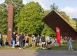 A group of over 20 people of a range of ages stood and sat by the Concert Platform in Crystal Palace Park at a party to celebrate the handover of the park to the Crystal Palace Park Trust.